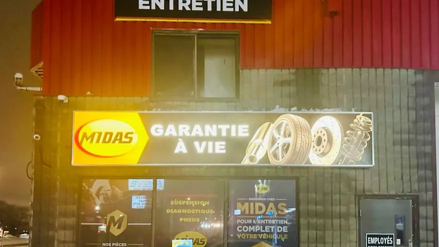 Enseigne Midas Garantie à vie illuminée le soir à Rivière-des-Prairies